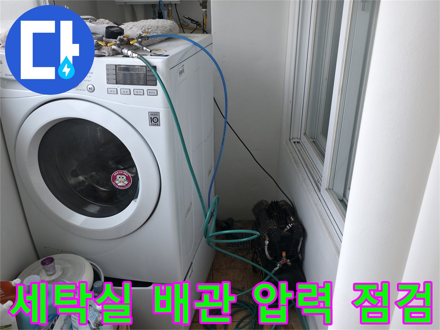 세탁기 뒤쪽 배관에 연결된 공압 테스트 장비 모습