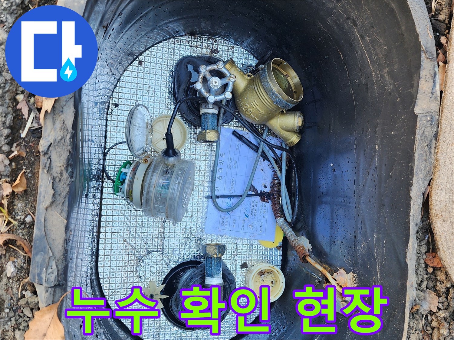 물기가 있는 계량기 함 내부와 노출된 배관 부품 사진