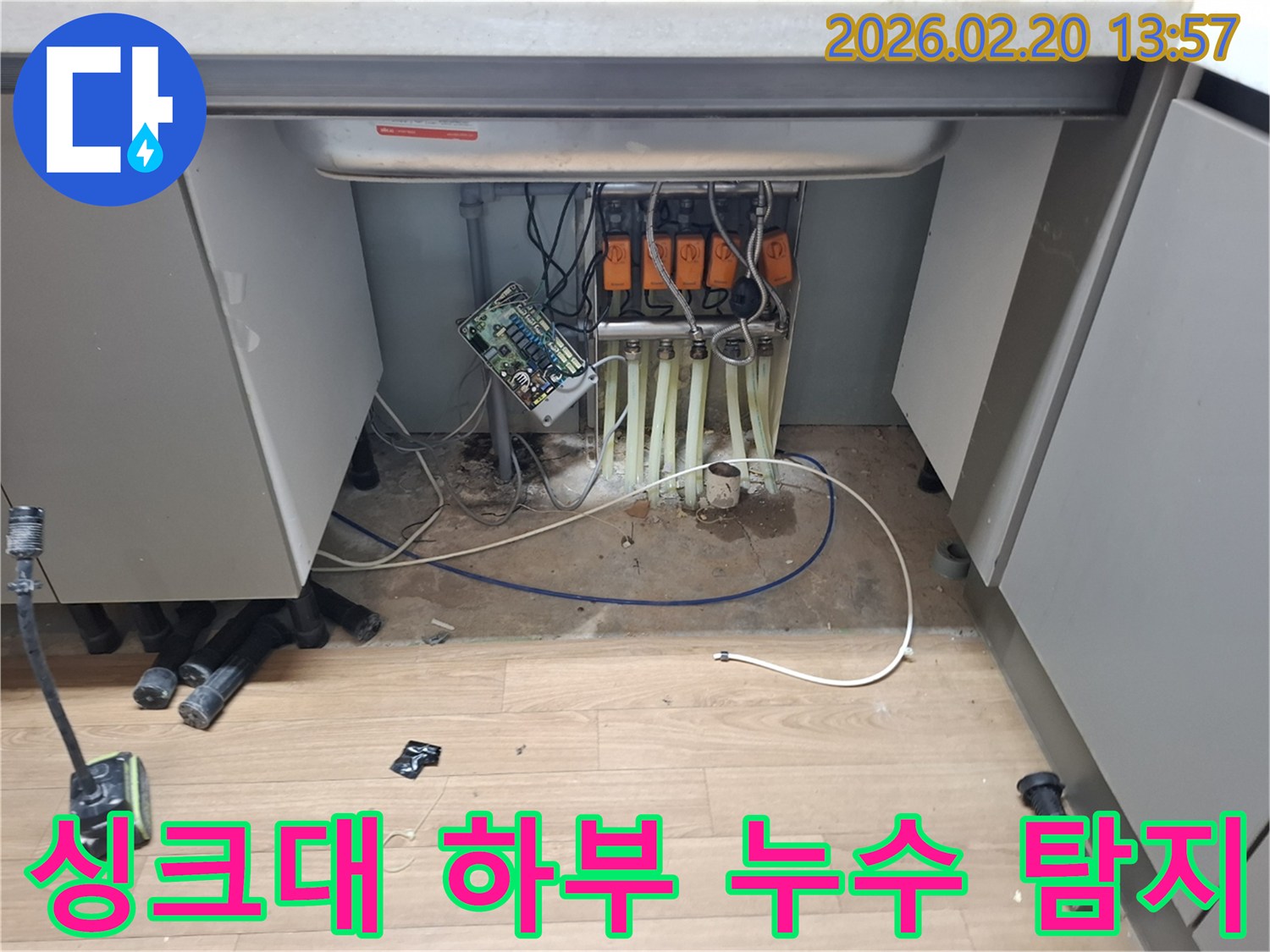 싱크대-아래-복잡하게-설치된-배관과-장치들-사이에서-발생한-누수-지점을-정밀하게-조사하는-모습입니다