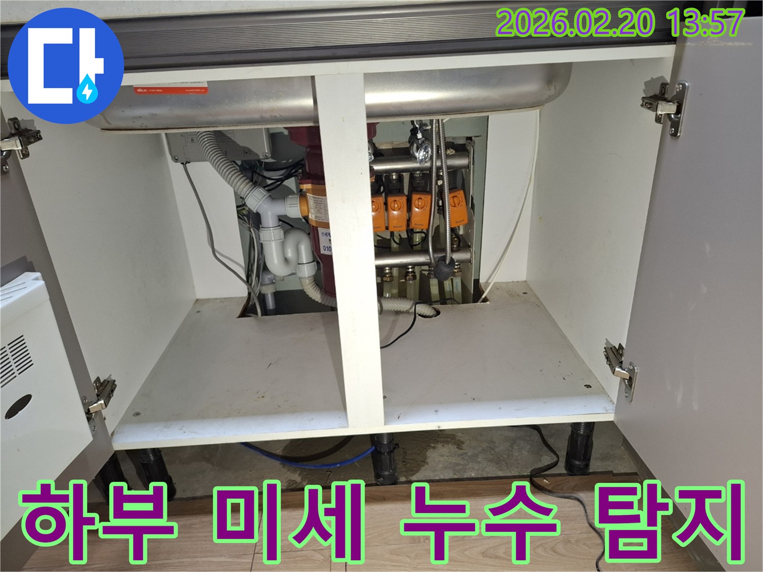 싱크대 하부-배관과 연결 부위에서-미세하게 물이 새는 현장을-면밀히 점검하는 모습