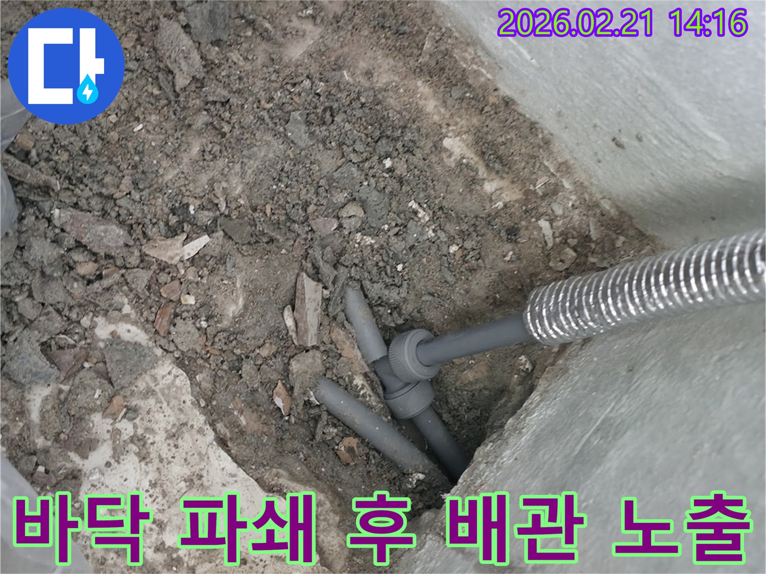 누수 문제를 해결하기 위해 바닥을 파쇄하고 배관을 드러낸 현장 사진입니다.