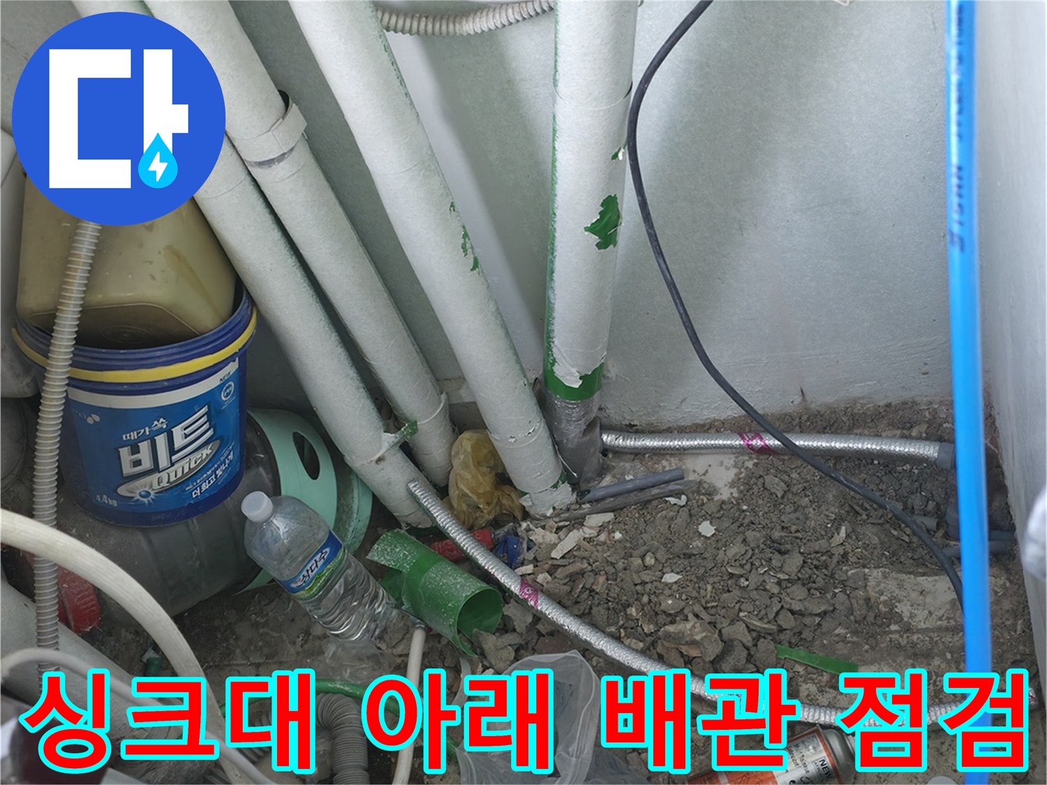 주방 싱크대 하단 배관들의 연결 상태와 점검 장비를 보여주는 사진입니다.