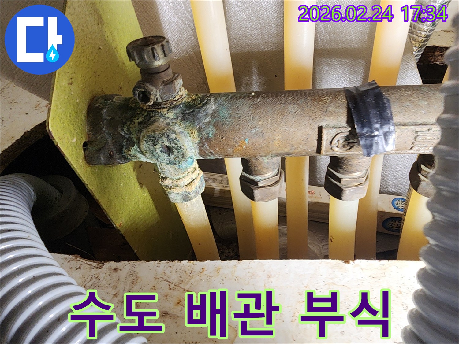 이 이미지는 아파트 수도 배관 분배기의 배관에서-발생한 심각한 부식과-그로 인한 누수 현장을 보여주며-정밀 진단을 통한 해결이 시급함을 나타냅니다.