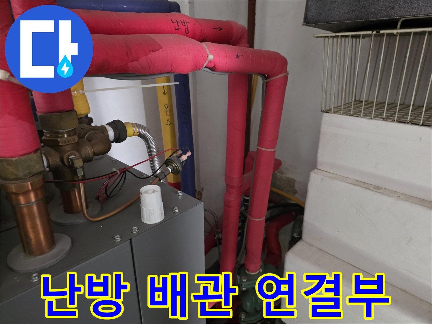 분홍색 보온재로 마감된 난방 배관의 연결 부위 상세 사진