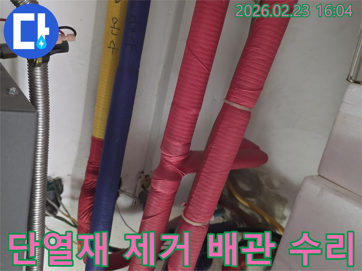 붉은색 단열재로 감싸진 배관-누수 지점 확인을 위해 단열재를 제거하고 배관 수리 준비 중