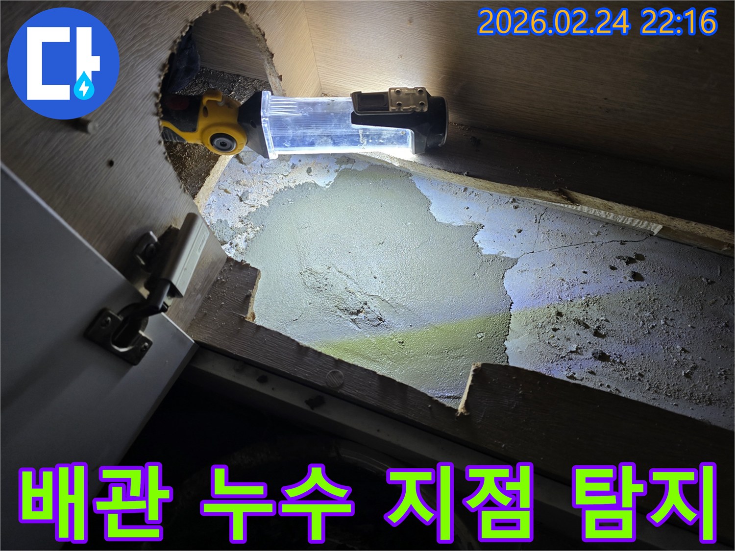 어두운-싱크대-하부에서-배관-누수-지점을-정확히-찾기-위해-조명-장비를-활용하는-누수-전문가