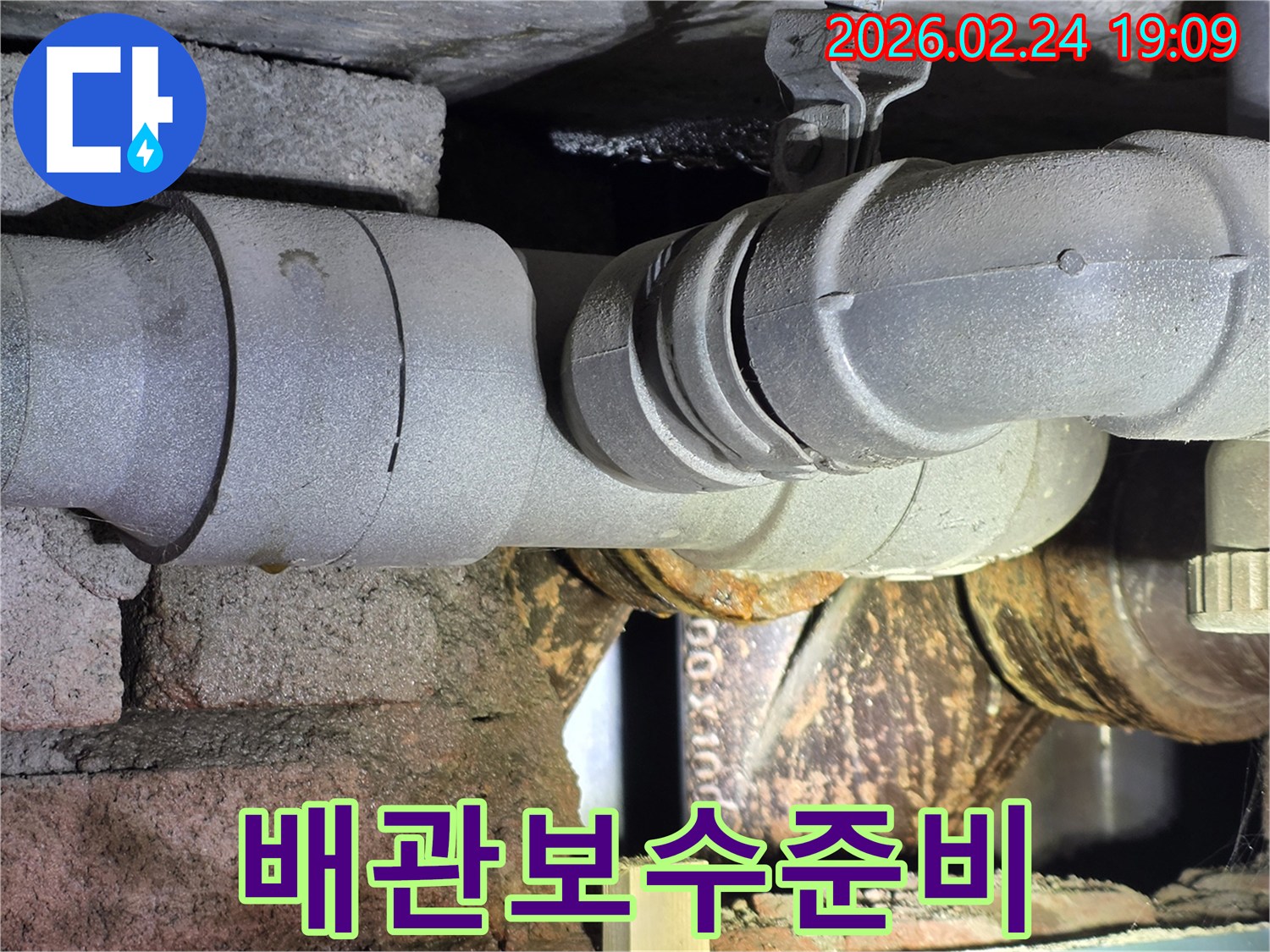 누수-배관을-보수하기-위해-손상된-부위를-정리하고-있는-작업-현장-사진입니다.