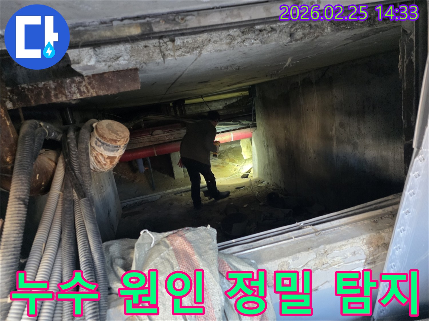 손전등을 든-누수 전문가가-복잡한 배관 사이에서-누수 지점을-확인하는 중