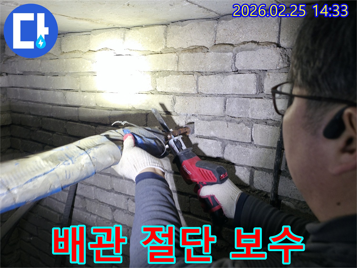 숙련된-엔지니어가-어둡고-좁은-공간에서-랜턴을-비추며-누수-배관을-정확히-절단하고-있습니다.