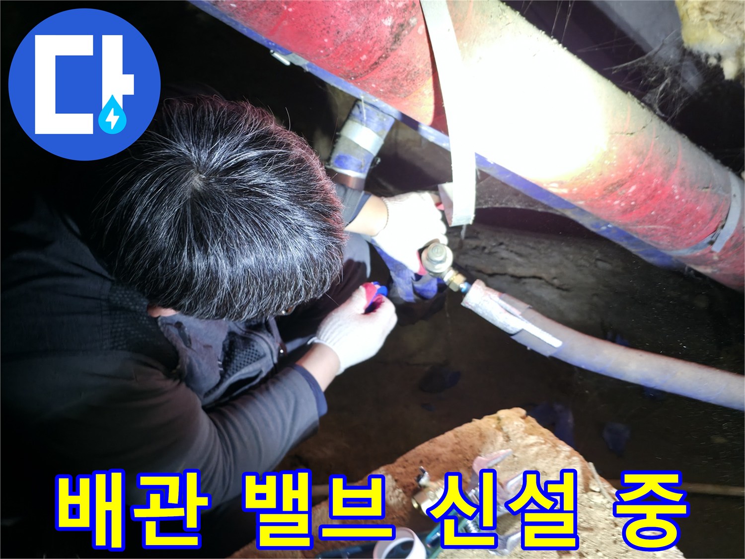지하 배관실에서 볼밸브를 이용해 배관을 재연결하는 모습