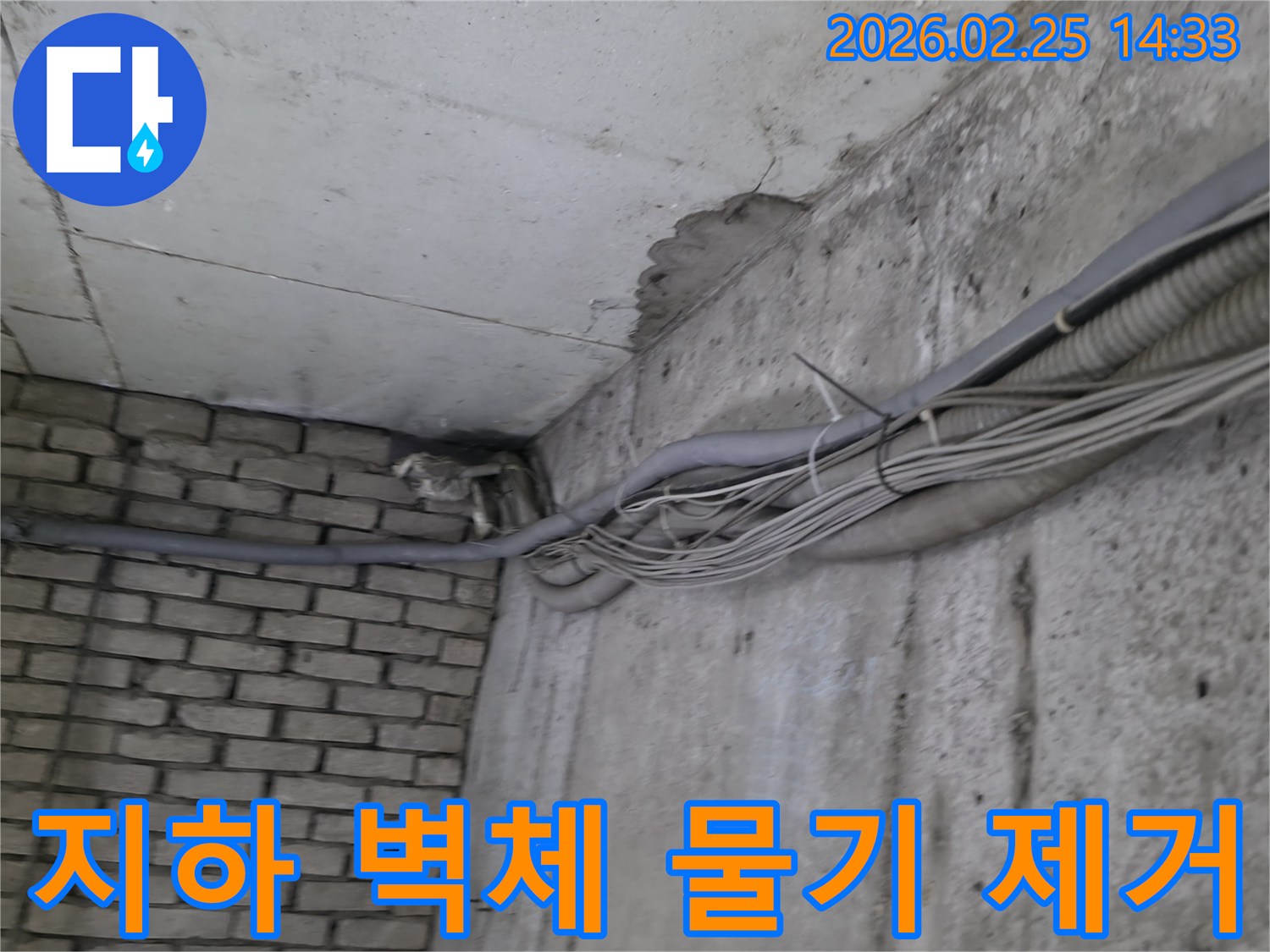지하 벽면의-콘크리트와-벽돌 벽이 만나는-지점에서-발견된-오랜 누수로 인한-물자국과-주변의 복잡한 배관