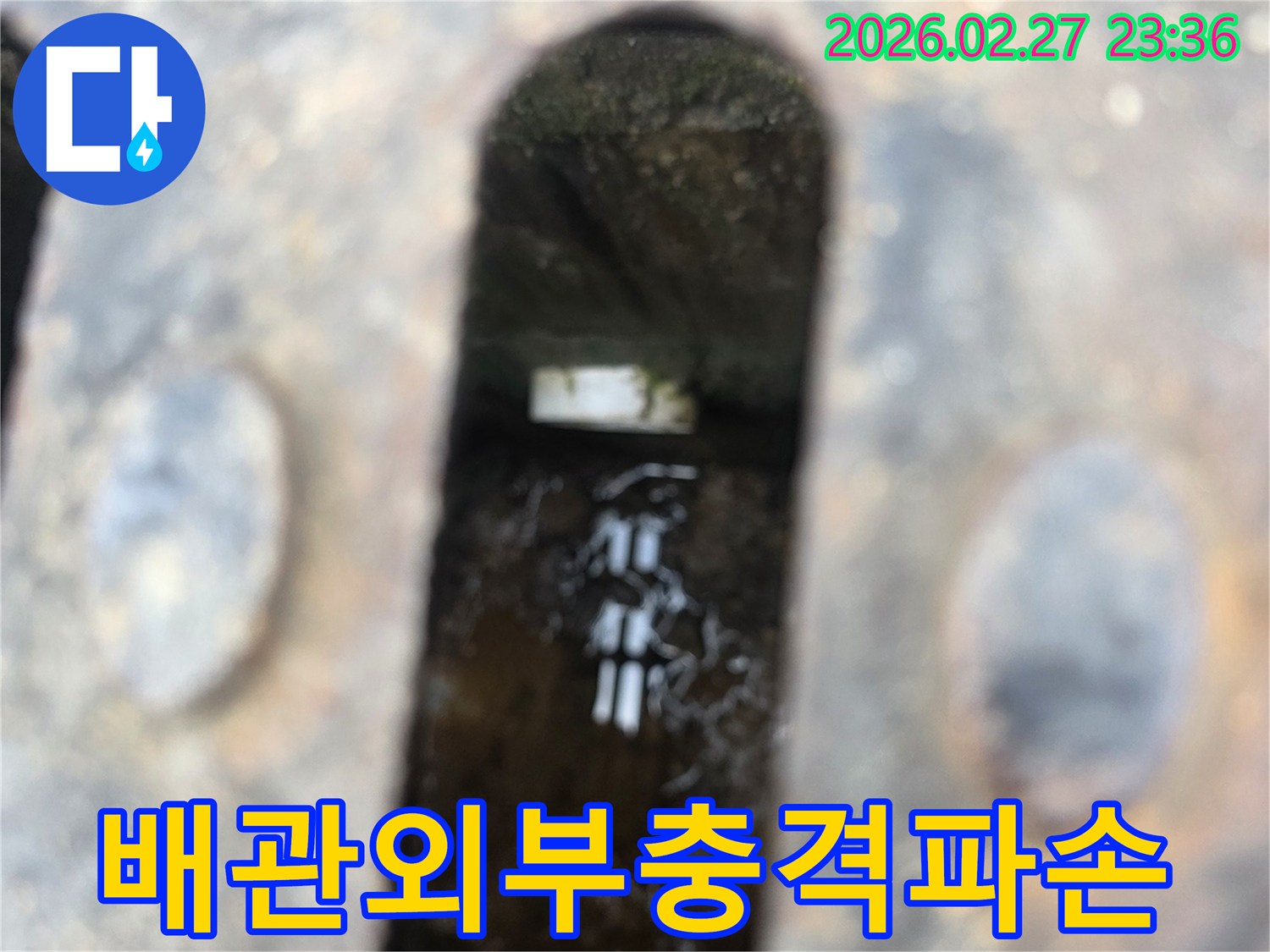 녹슨-철제-덮개-아래-고인-물과-물속에-잠긴-외부-충격으로-파손된-듯한-배관-조각이-보이는-누수-현장