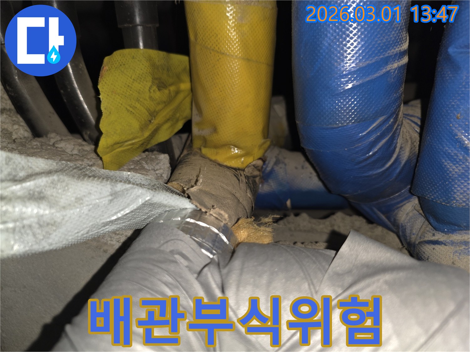 단열재가 파손되어-배관이 외부 환경에 노출되어-부식 위험이 높은 상태를 보여줍니다.
