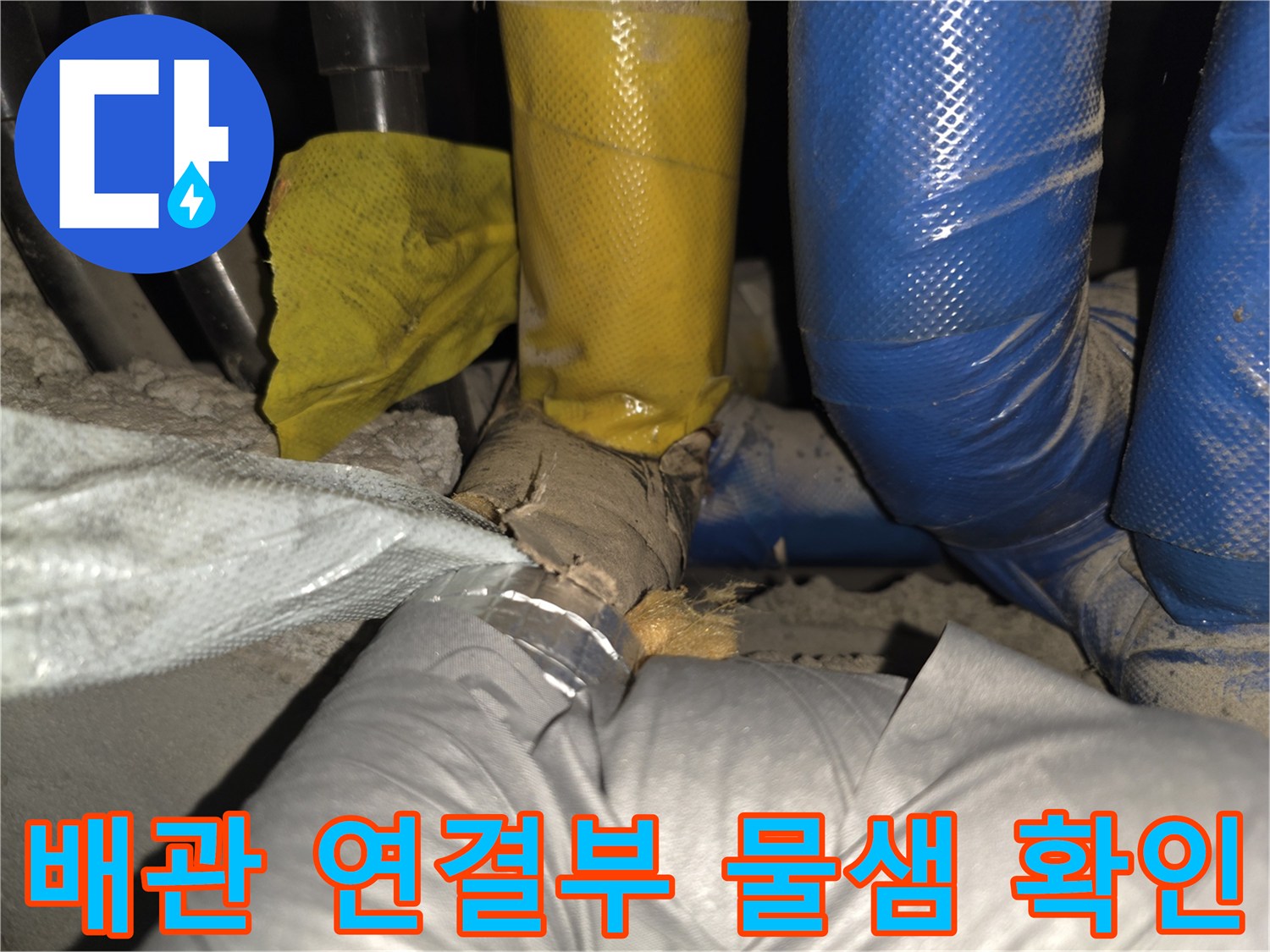 보온재가 젖어 있는 노란색과 파란색 배관의 모습