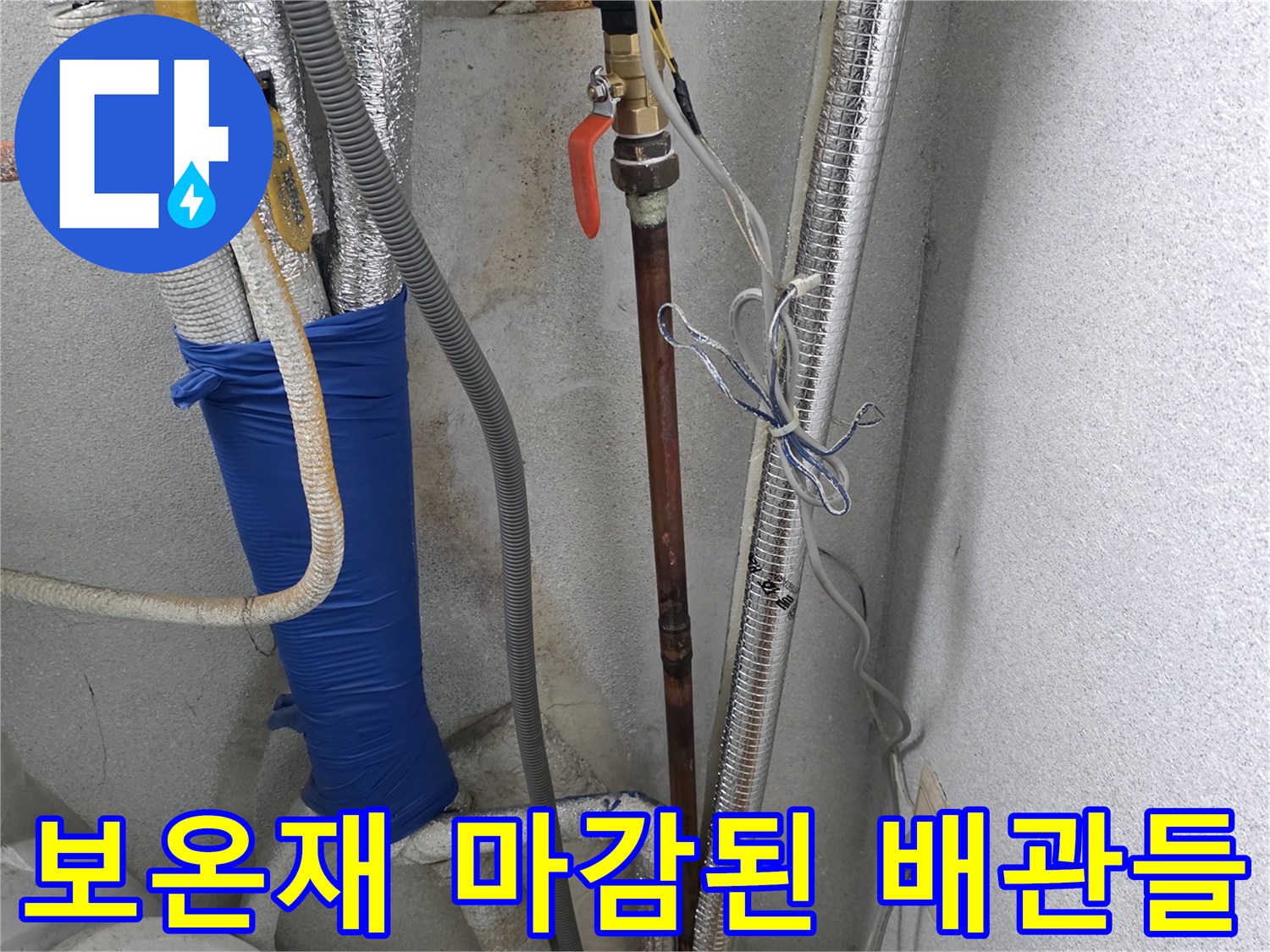 세탁실 벽면을 따라 설치된 은박 보온재 배관과 파란색 덮개 부속