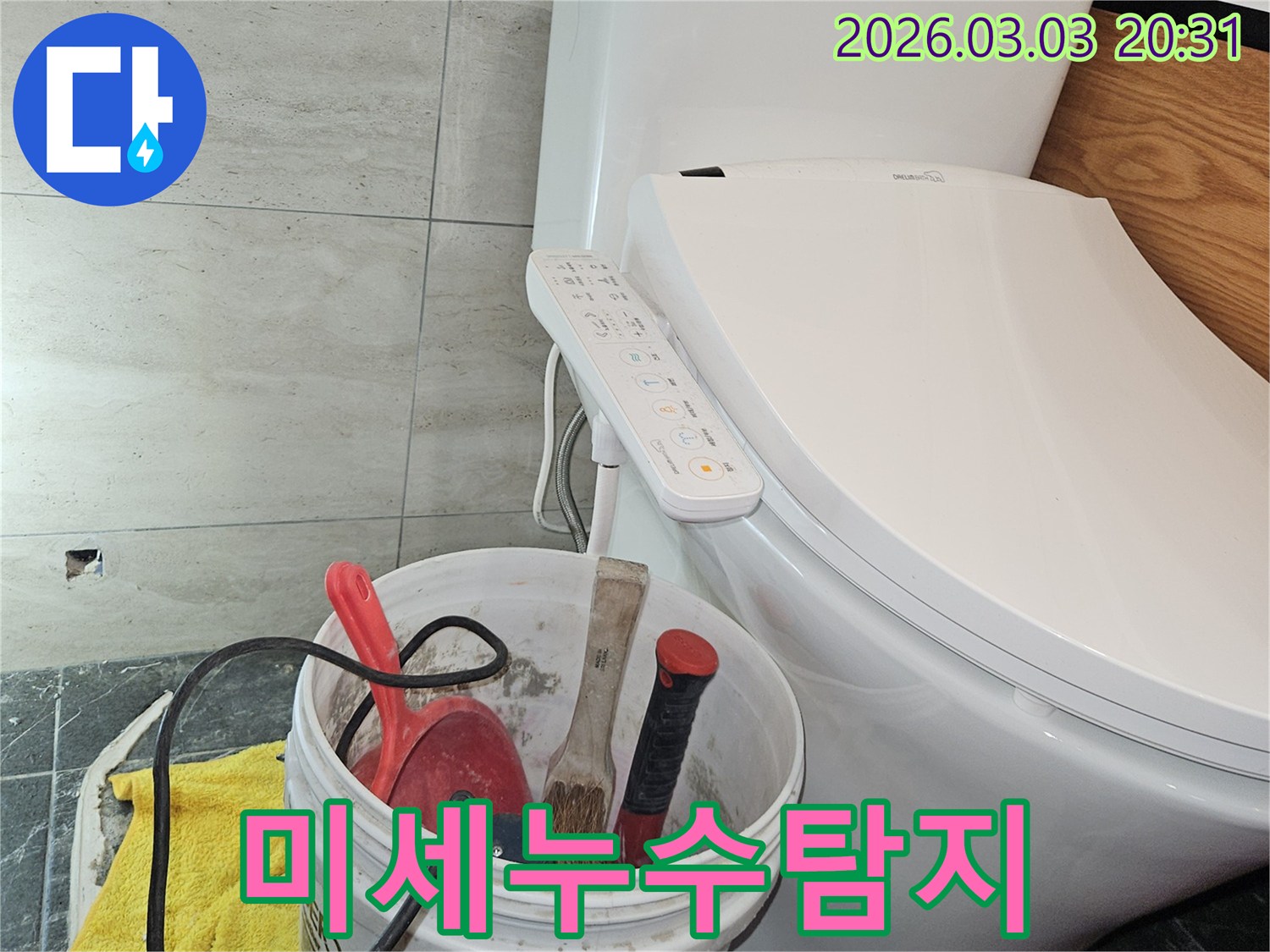 누수 공사를 위해 가져온 장비들이-화장실 변기 옆에 가지런히 놓여-작업 시작을 알리는 모습입니다.