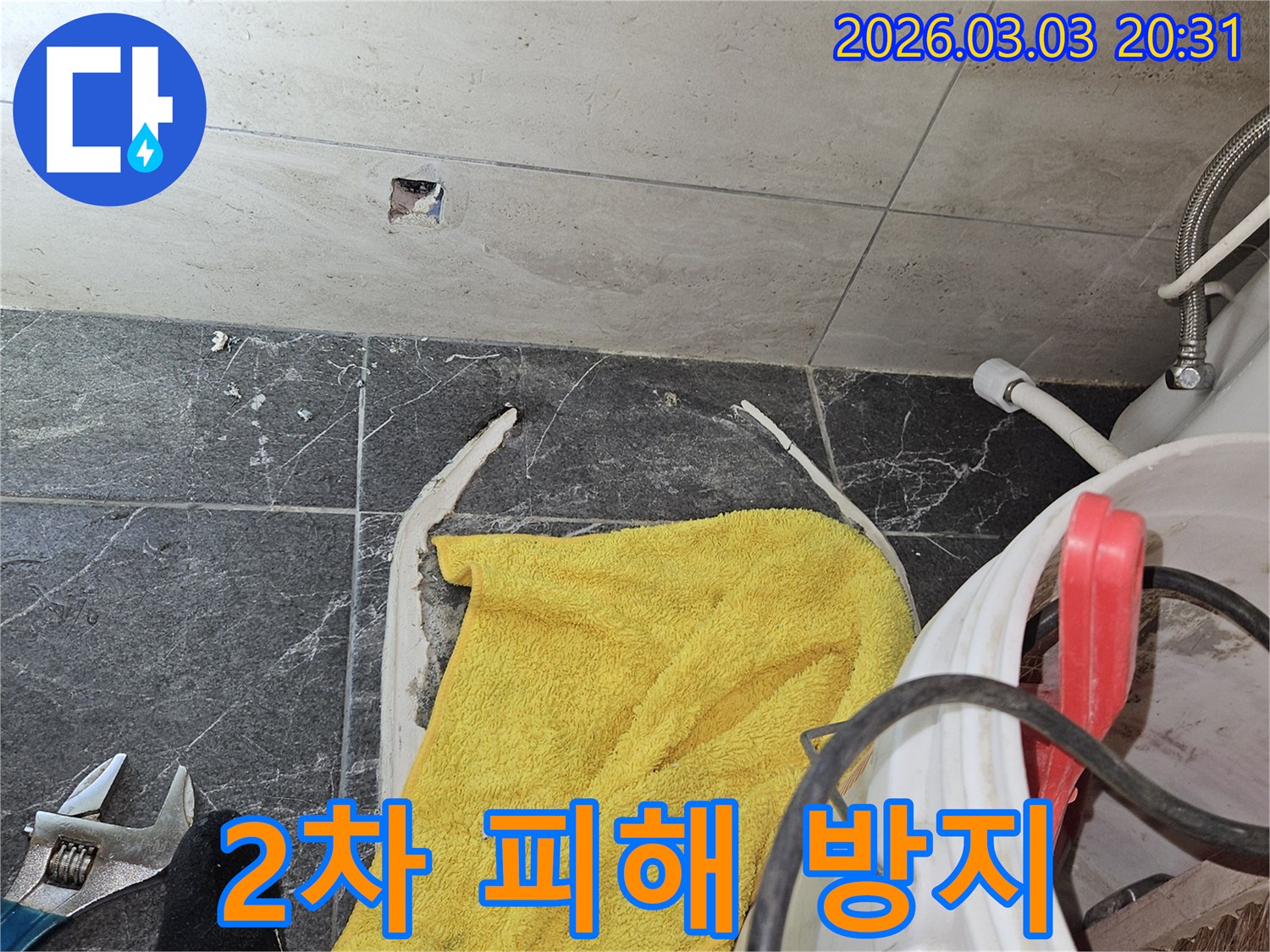 화장실-누수-현장에서-추가적인-물-피해를-막기-위해-물기를-제거하고-임시-조치를-취하는-모습입니다