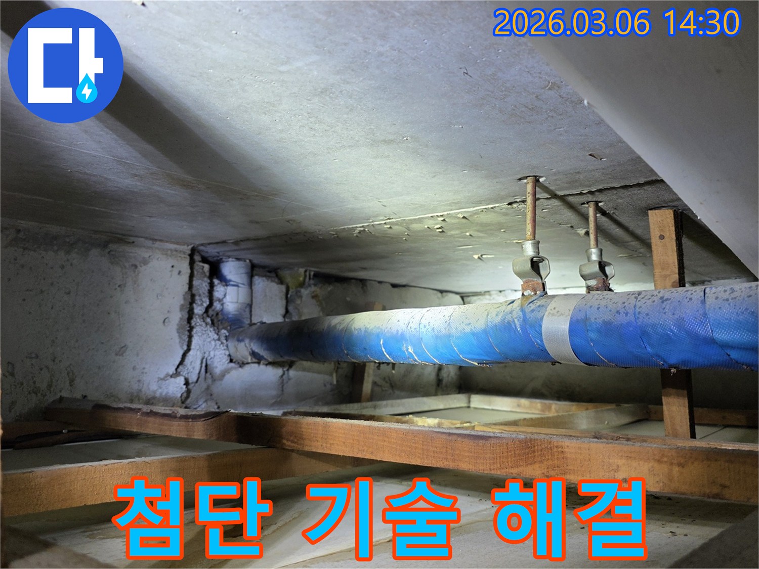 지하 공간의 파란색 배관과-손상된 콘크리트 벽면을-누수 엔지니어가-첨단 기술을 활용하여-누수 문제를 해결하기 위해-점검하는 모습