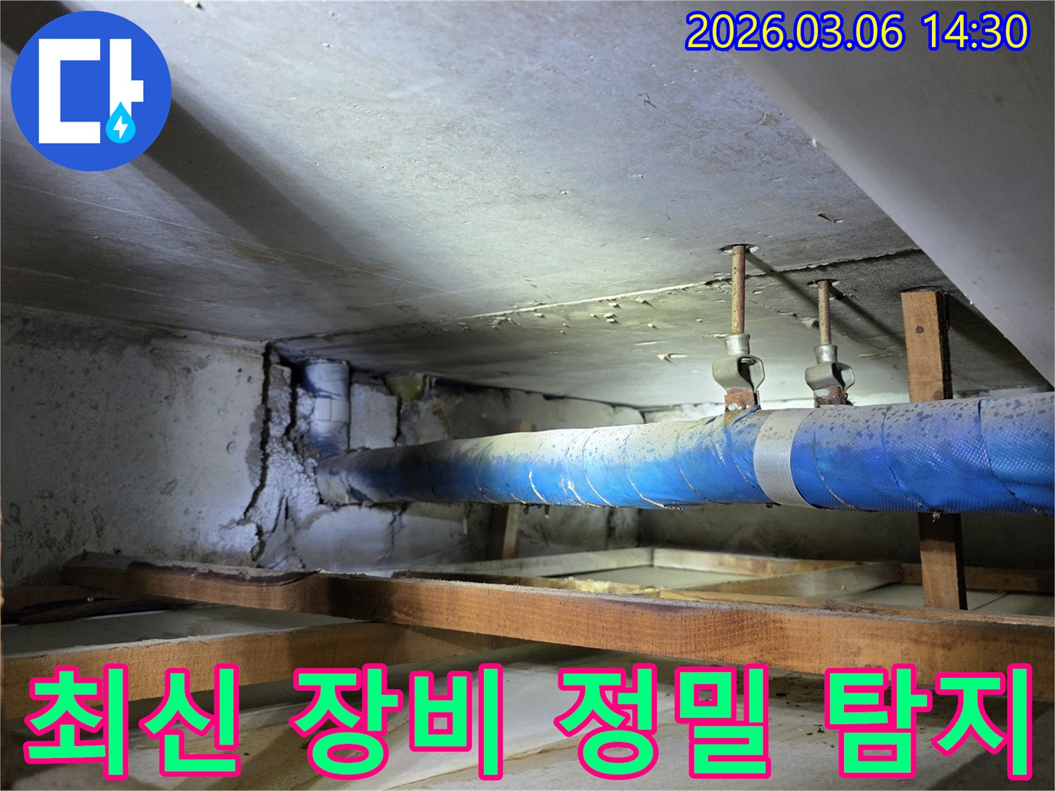 지하 공간의 파란색 배관과-손상된 콘크리트 벽면을-누수 엔지니어가-최신 장비를 활용하여-정밀하게 탐지하는 모습