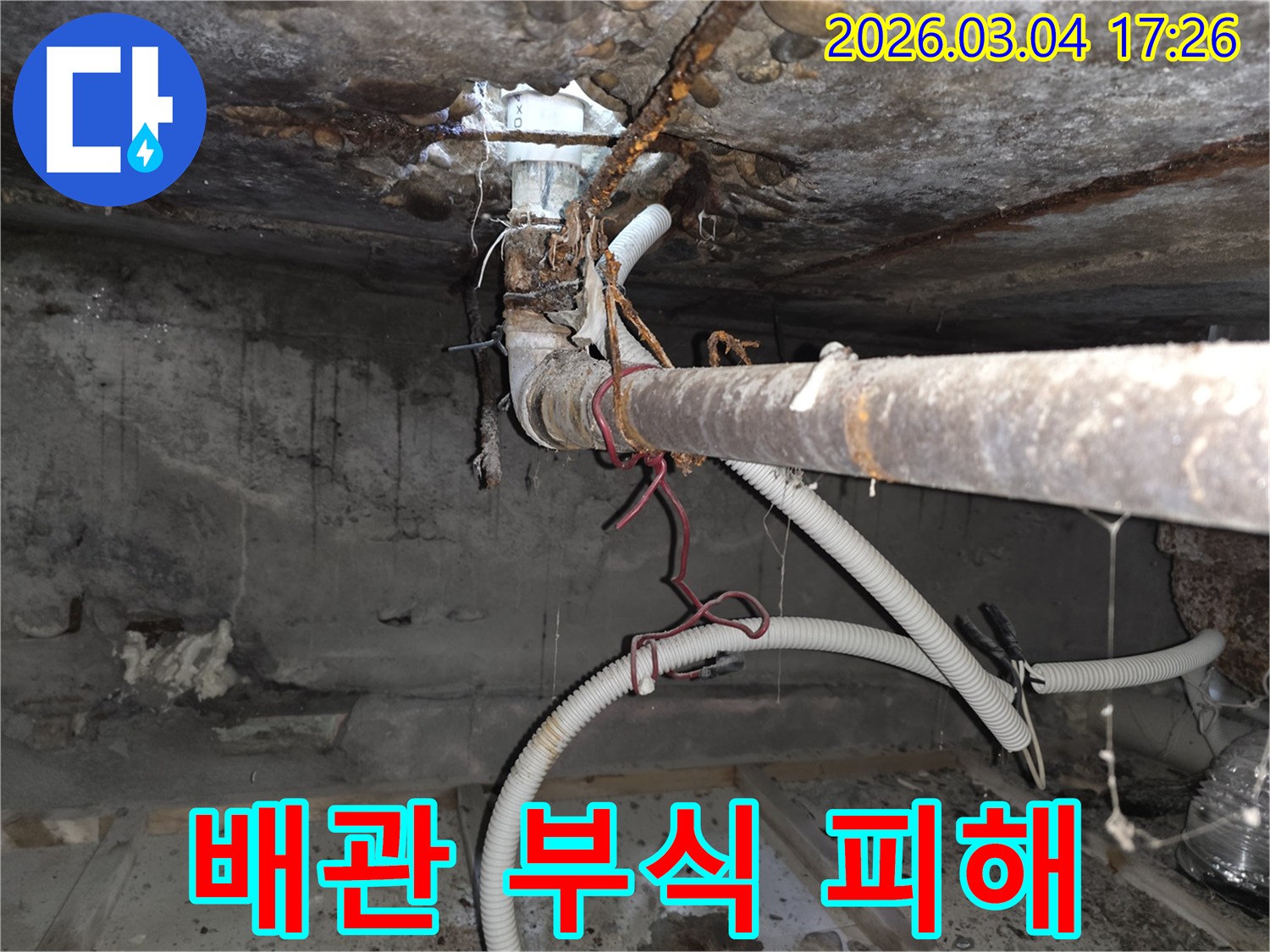 오래된 건물-지하 배관의-심각한 부식으로-인해 발생한-누수 현장과-그로 인한-콘크리트 손상을-보여주는-사진입니다