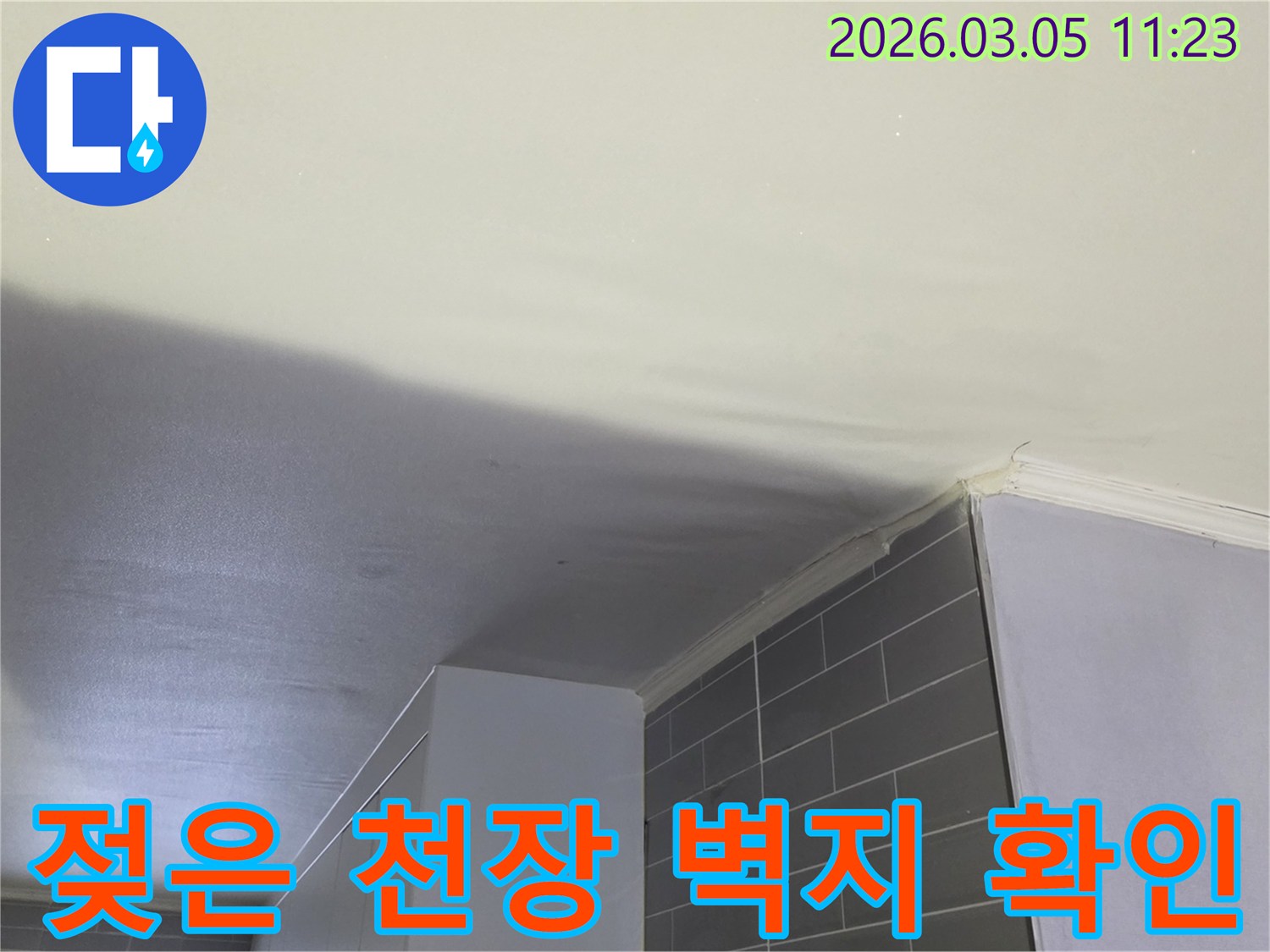 상부층-누수로-인해-천장-벽지가-젖어-변색된-상태를-보여줍니다.