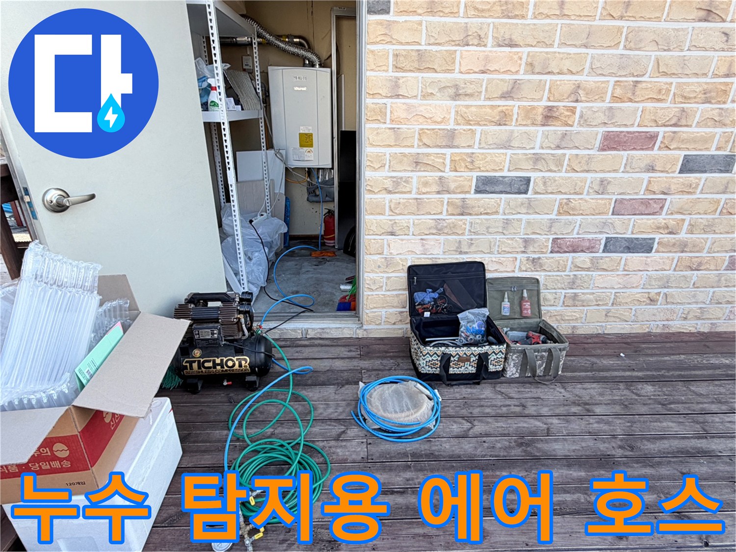배관 압력 테스트를 위해 펼쳐진 파란색 호스와 콤프레샤 장비