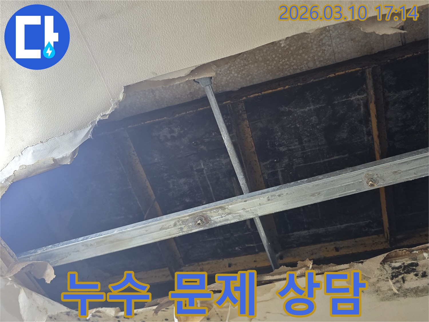 천장 마감재가 찢겨져 내부 구조물이 노출되고-물기로 인해 변색된 누수 현장의 모습입니다
