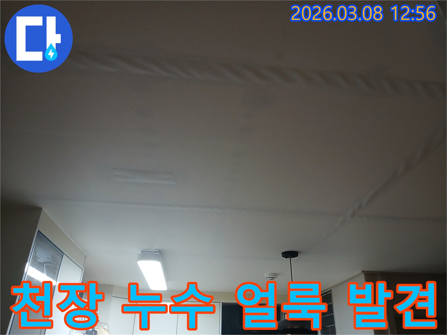주방 천장에 물이 새어-얼룩과 변색이 생긴-누수 현장을 보여주는 사진