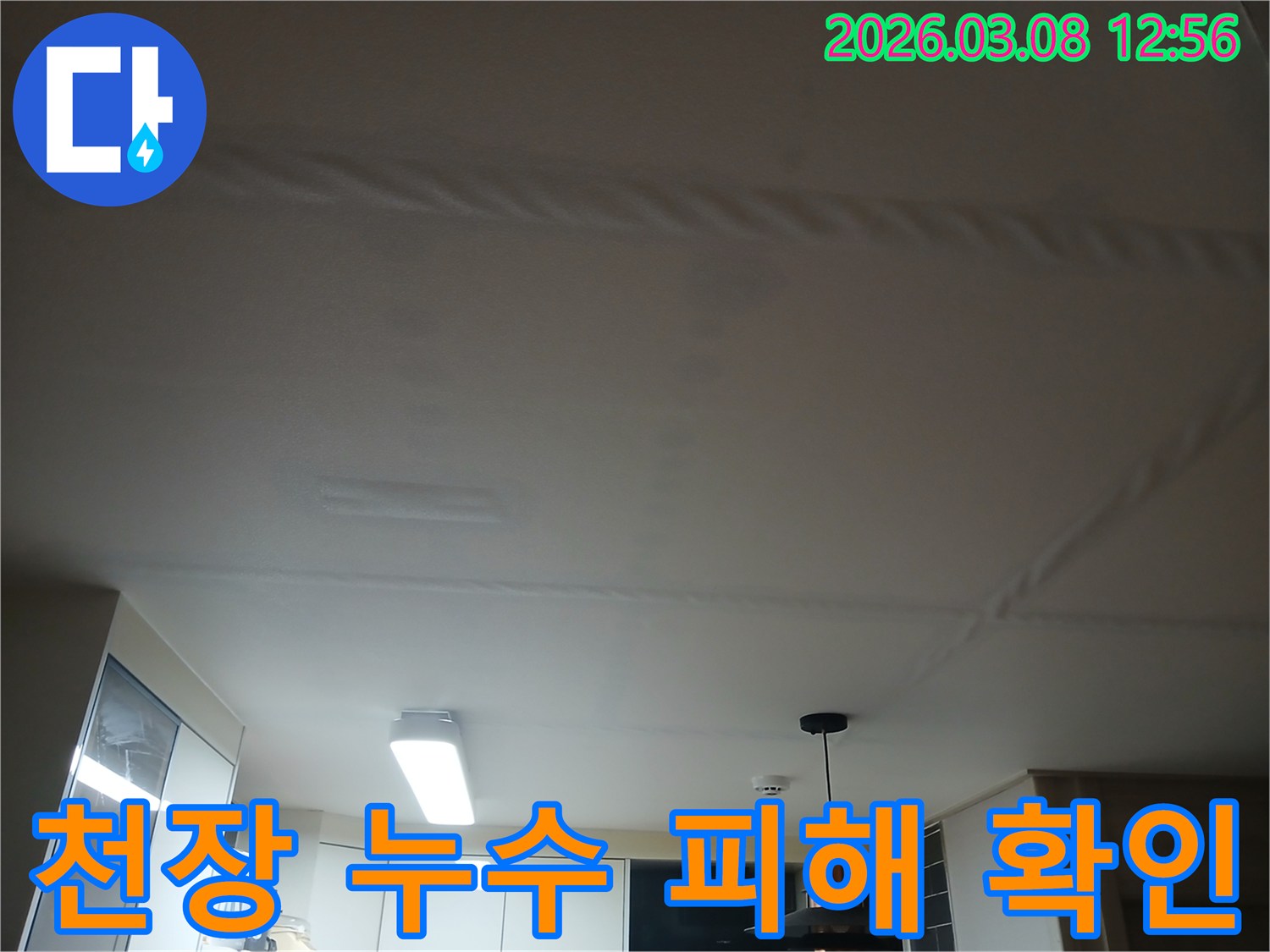 주방 천장에 물이 새어-얼룩지고 마감재가 손상된-누수 현장을 보여주는 사진
