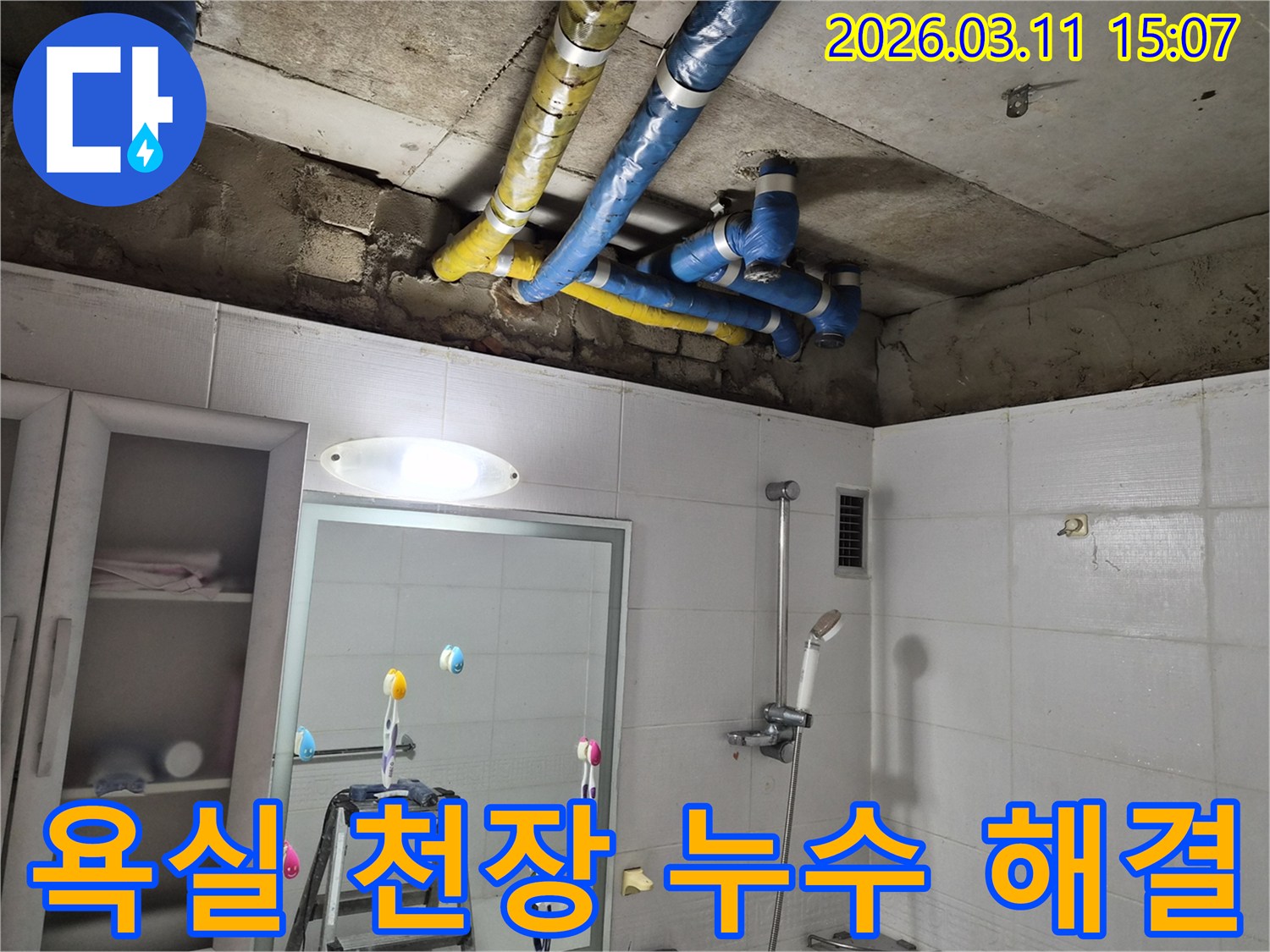 파란색과 노란색으로 감싸인-배관 주변에-물자국이 선명하게 보이며-누수 해결이 시급합니다