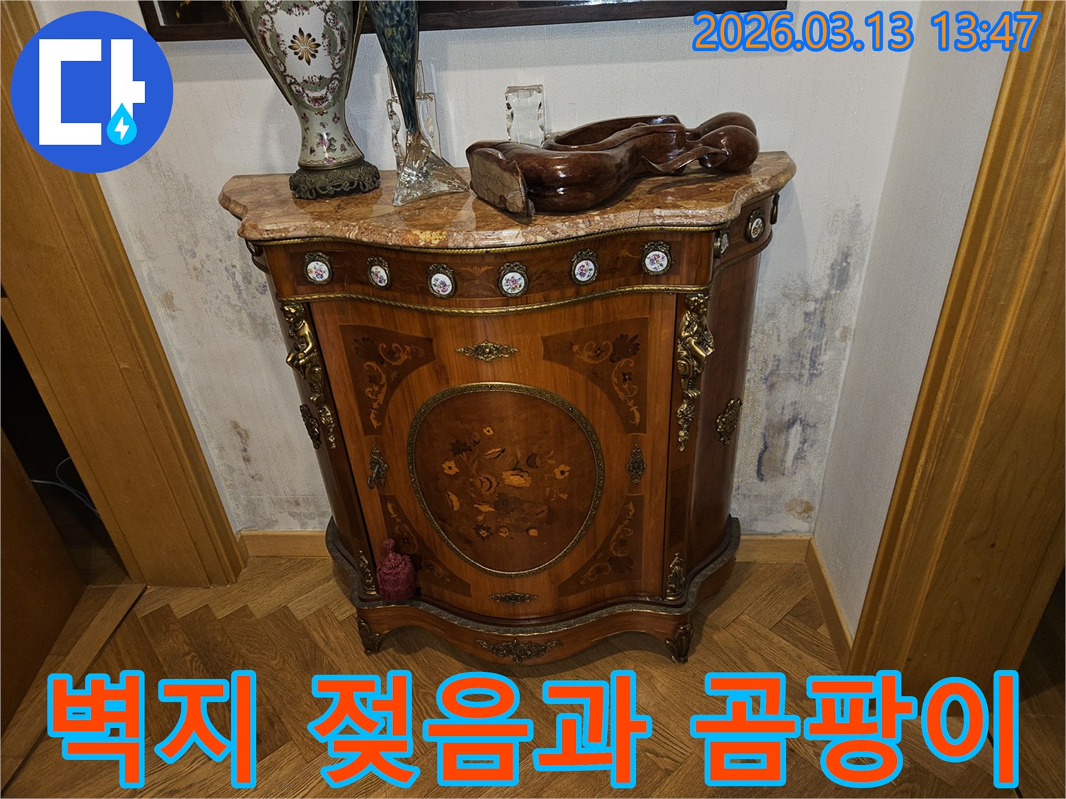 고급스러운 가구 옆-벽에 나타난-누수로 인한-벽지 손상과-얼룩진 곰팡이 모습
