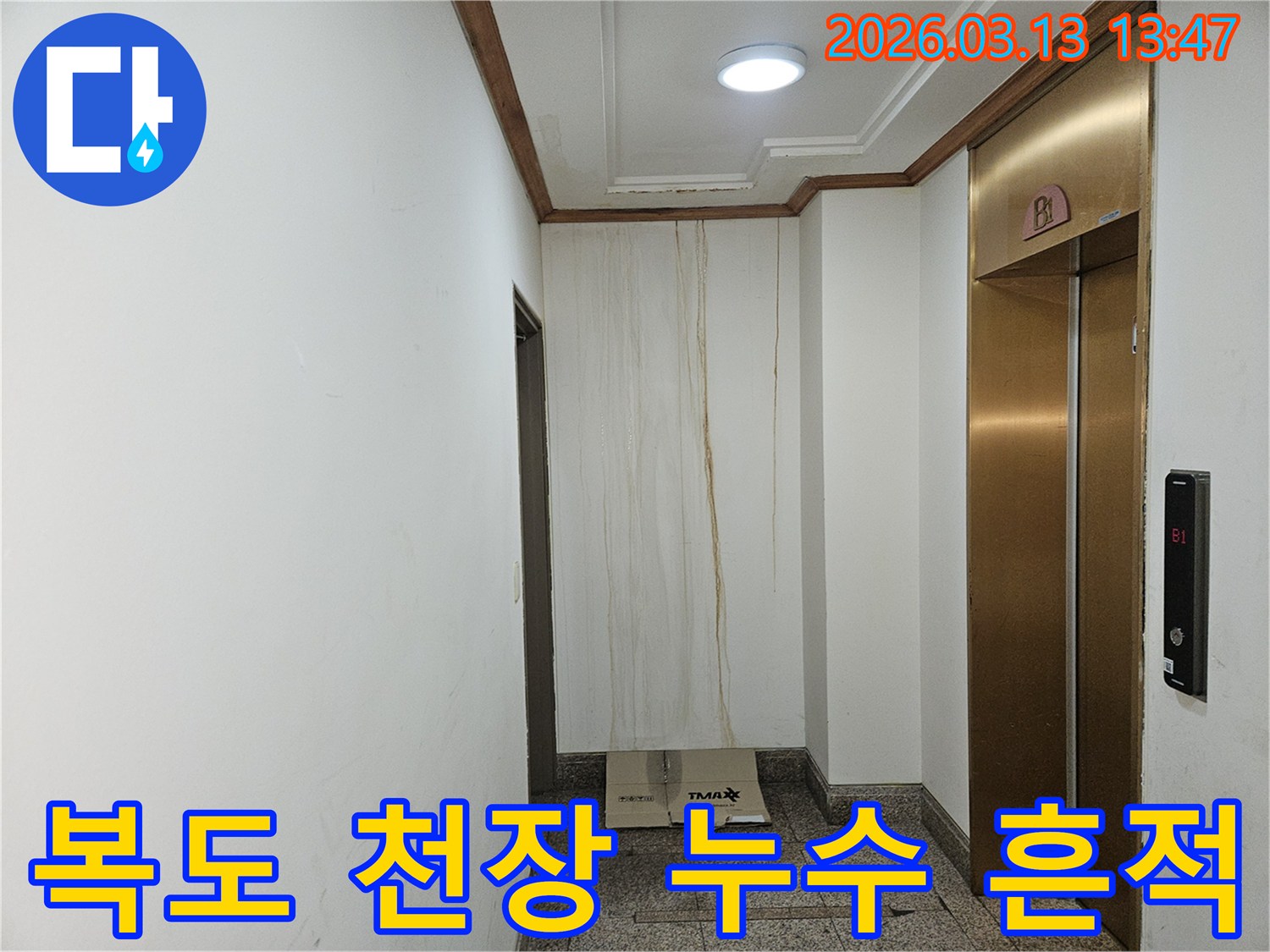 이 사진은 아파트 복도 천장에서 시작되어-벽면을 타고 흘러내린 누수 흔적을 보여줍니다-오랜 시간 누수가 진행되어 벽지가 손상되었습니다