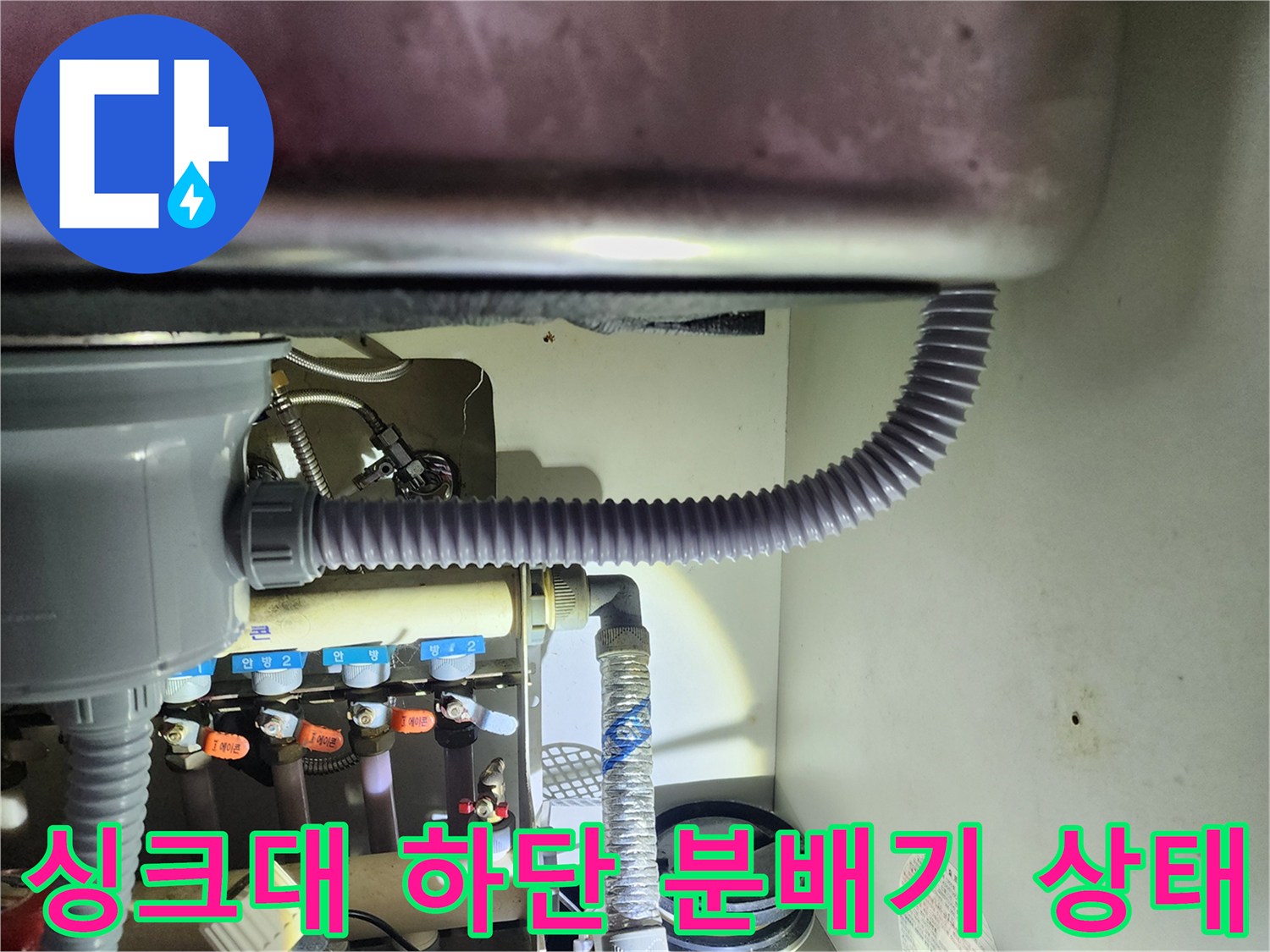 싱크대 아래 설치된 보일러 분배기 밸브와 주름 배관의 연결 상태