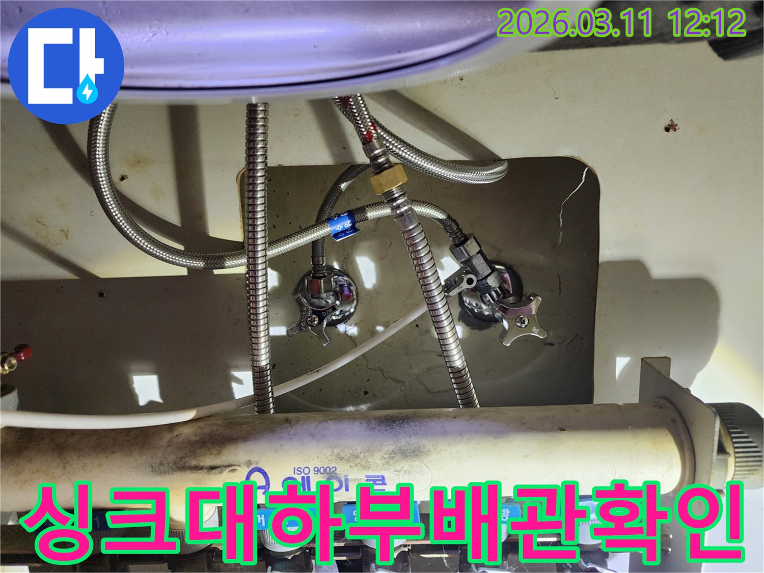싱크대-아래-설치된-에어컨-배관-분배기와-수도-호스-밸브를-정밀하게-살펴보는-이미지