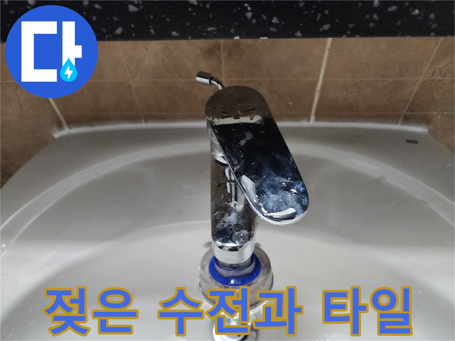 물기가 맺힌 세면대 수전과 욕실 타일 벽면입니다.