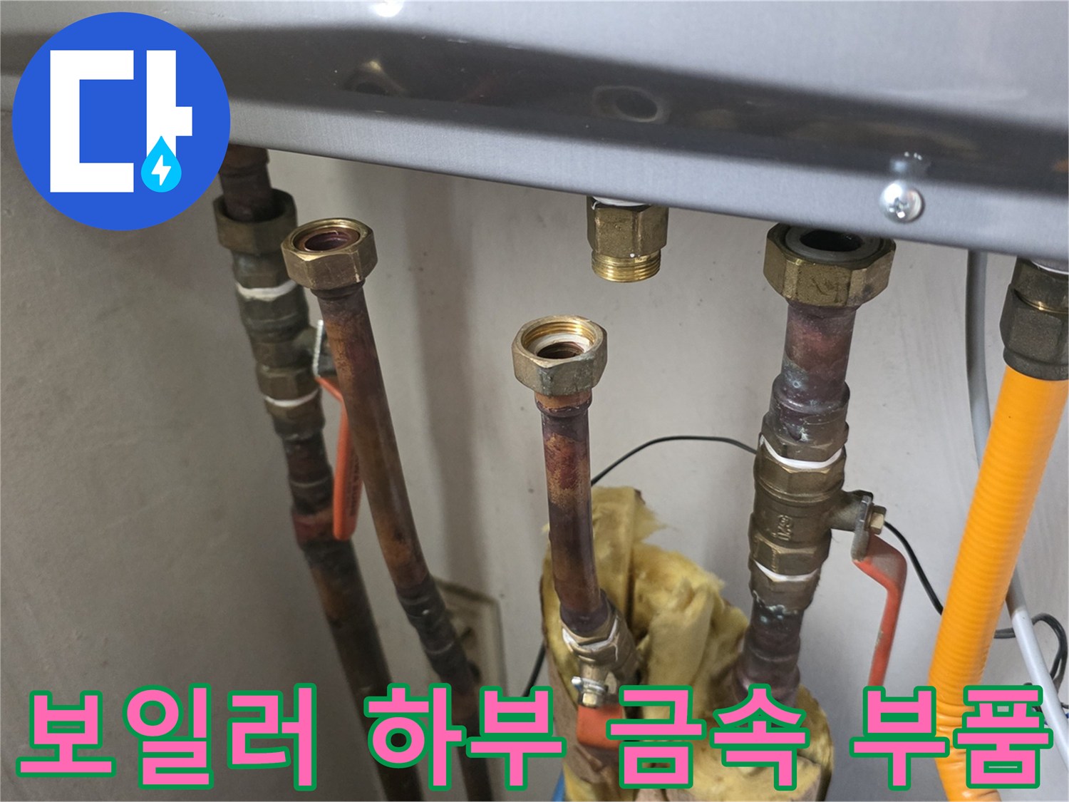 보일러 본체 아래에 연결된 여러 종류의 배관과 밸브입니다.