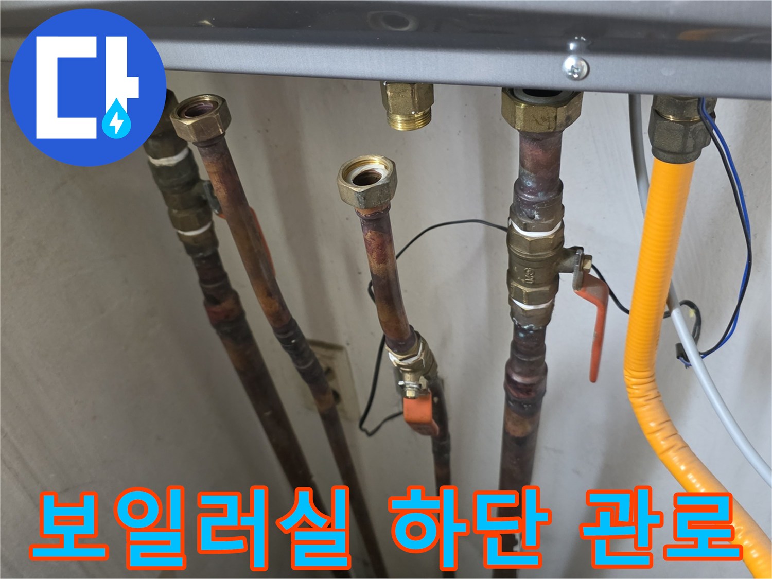 보일러-하단의-다양한-연결-배관들과-노란색-호스