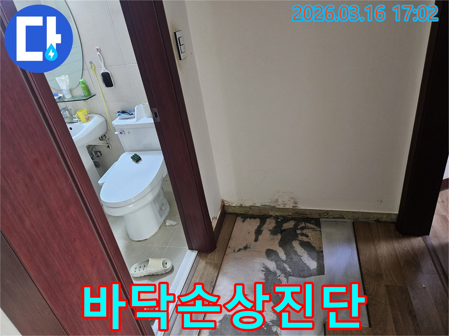 누수 탐지 후-욕실 앞 바닥재를-제거하고-곰팡이와-물자국이 드러난-상태를 보여주는-사진