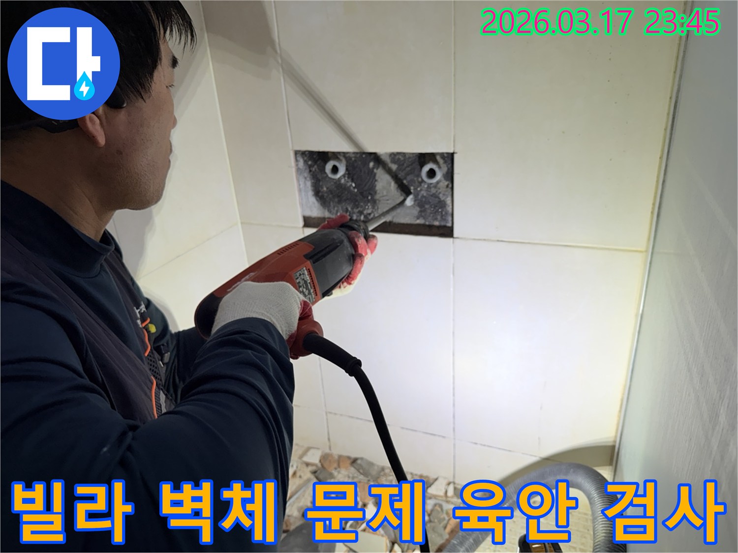 누수 공사 전문가가 빌라 욕실 벽면의 타일을 조심스럽게 파쇄하여-누수 원인 배관의 문제점을 육안으로 검사하는 모습입니다.