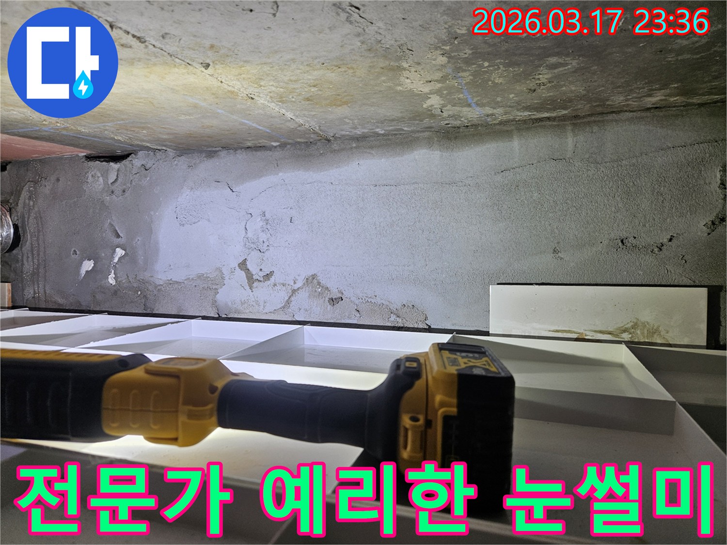 누수 전문 엔지니어가-천장 누수 현장에서-플래시를 이용해-세밀한 육안 검사를 진행하며-누수의 단서를 찾고 있습니다.