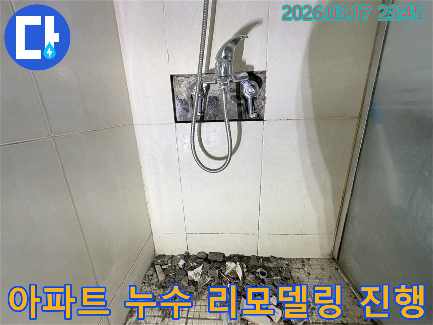 병점동 아파트 화장실에서-누수 피해 복구 및 리모델링을 위해-샤워 수전이 제거되고-바닥 타일이 파손된 채로-공사가 진행 중인 모습입니다.
