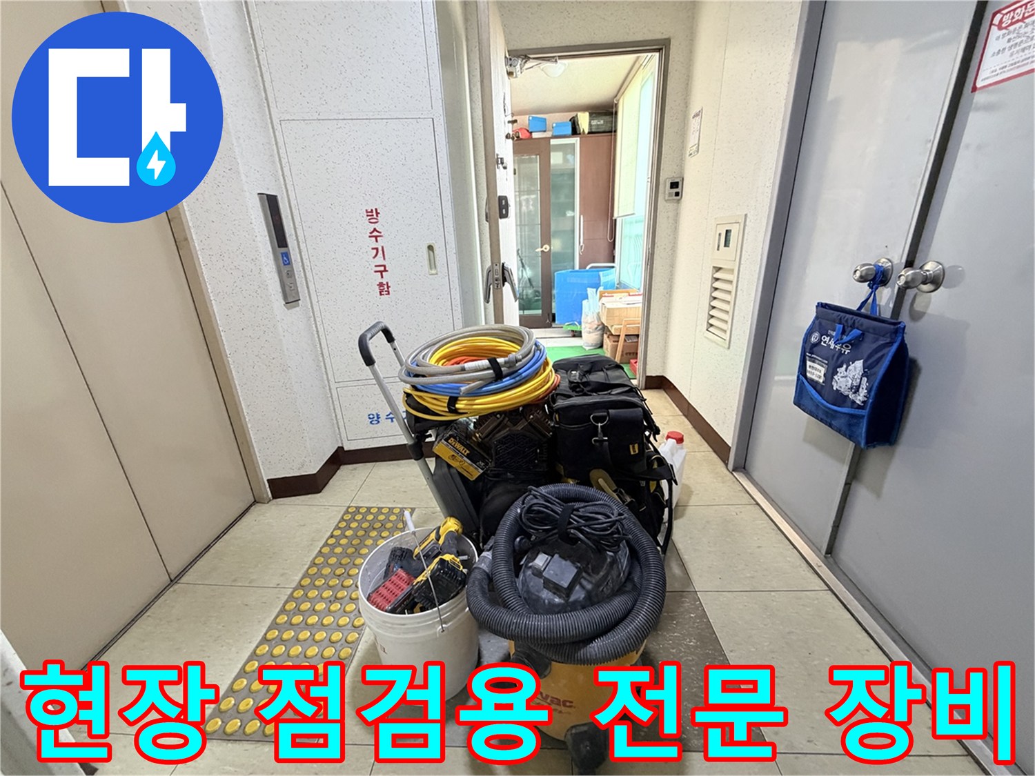 복도 바닥에 놓인 배관 검사용 가스 호스와 청소용 석션기