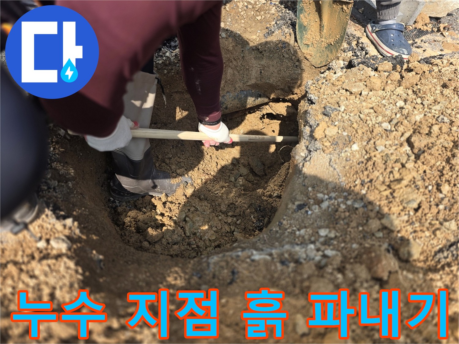 상수도 누수 부위를 찾기 위해 흙과 돌을 제거하며 작업 중인 모습