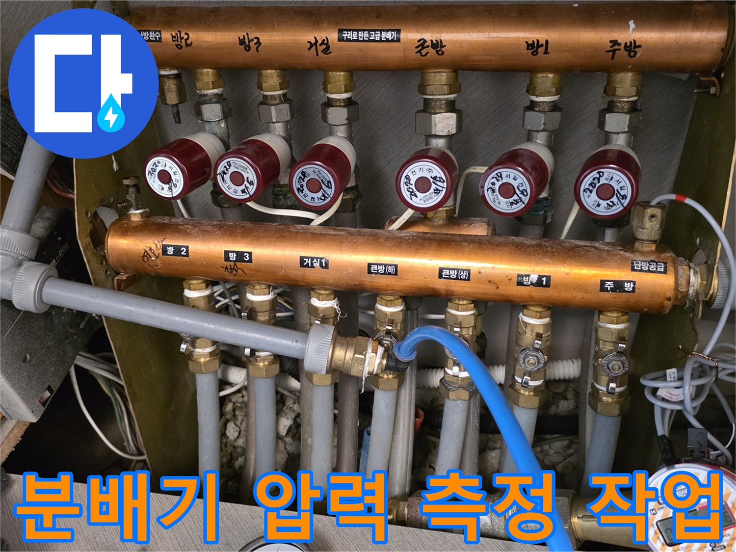 금속 소재의 난방 분배기와 연결된 파란색 호스