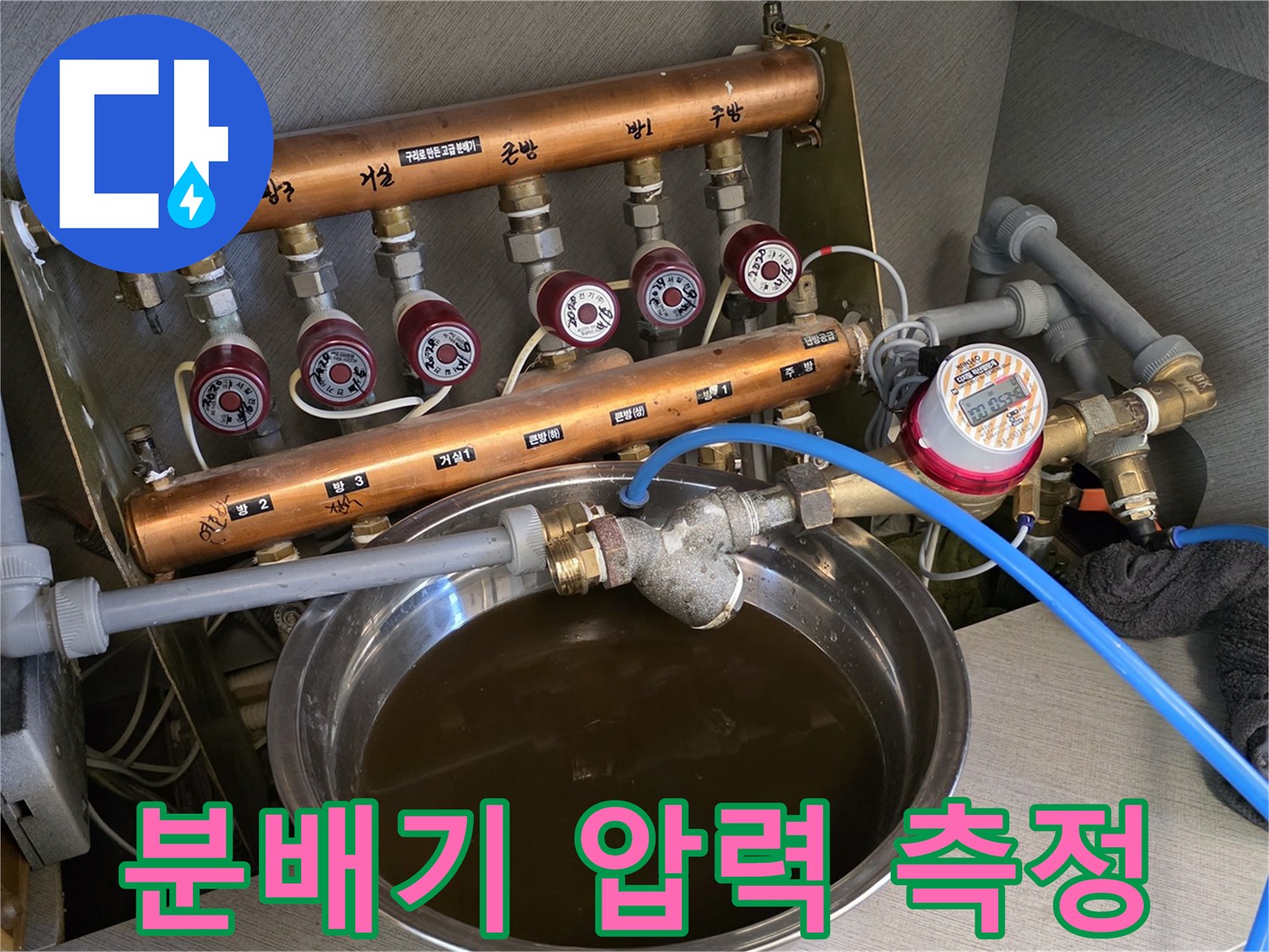 난방-분배기에-연결된-파란색-호스와-압력계-장치
