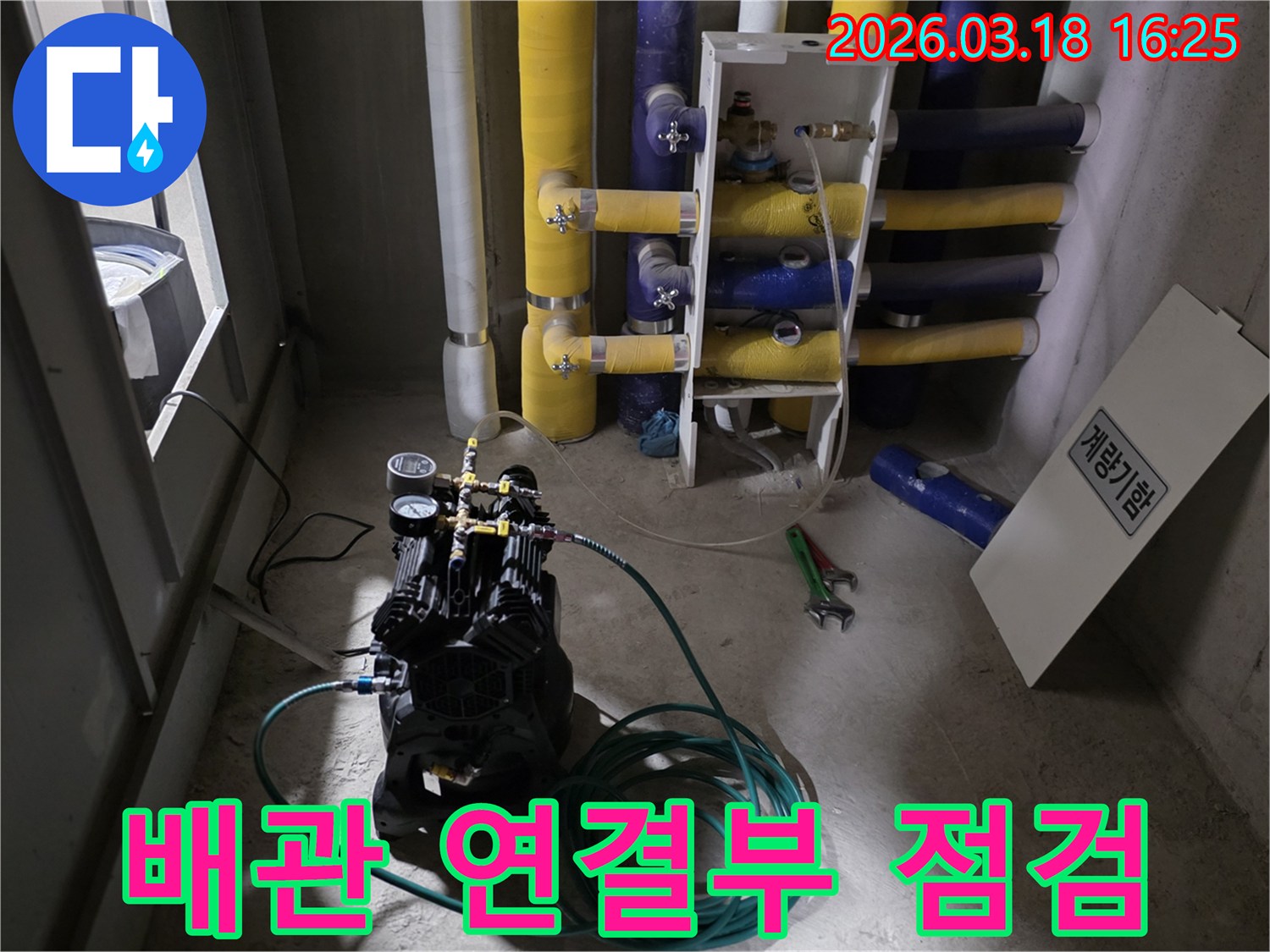 누수-탐지-전문가가-배관-연결부에-압력-테스트-장비를-설치하여-누수-여부를-점검하는-모습