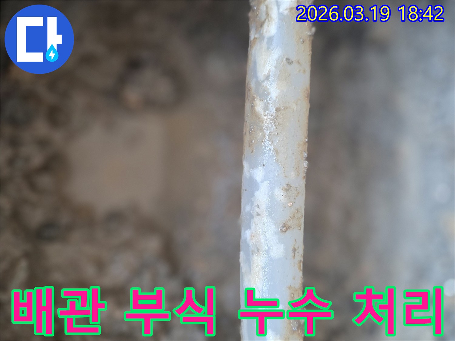 이 이미지는-오래된 배관에서-누수가 발생하여-주변에 물기가 고이고-부식이 진행된 모습을-보여주고 있습니다.