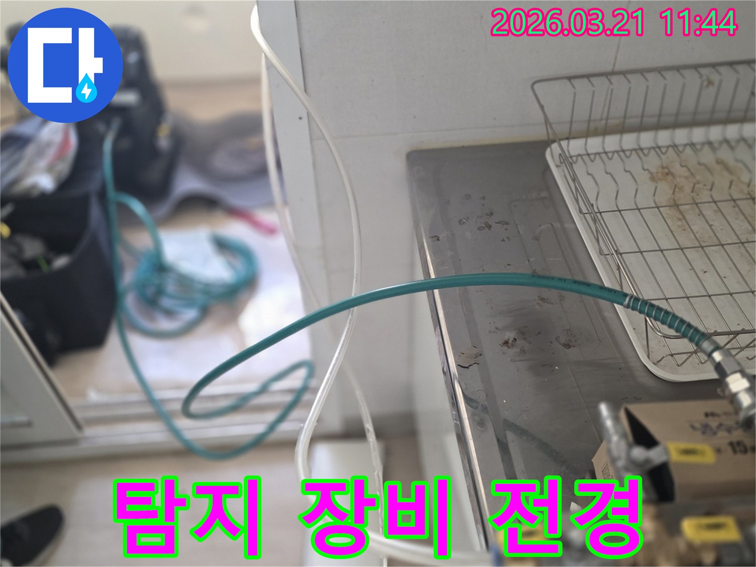 누수 엔지니어가-주택 싱크대 주변에-누수탐지 장비를 설치하고 있는-전체적인 작업 현장입니다