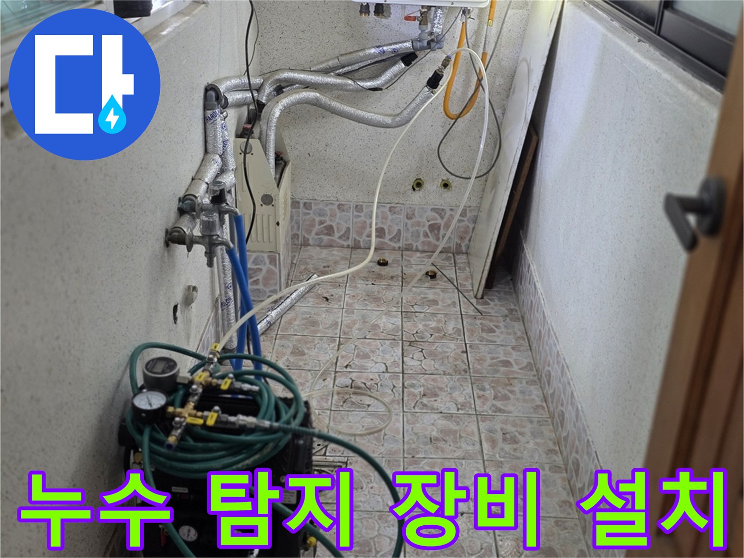 보일러실 벽면 배관에 연결된 공압 테스트기 및 호스 모습