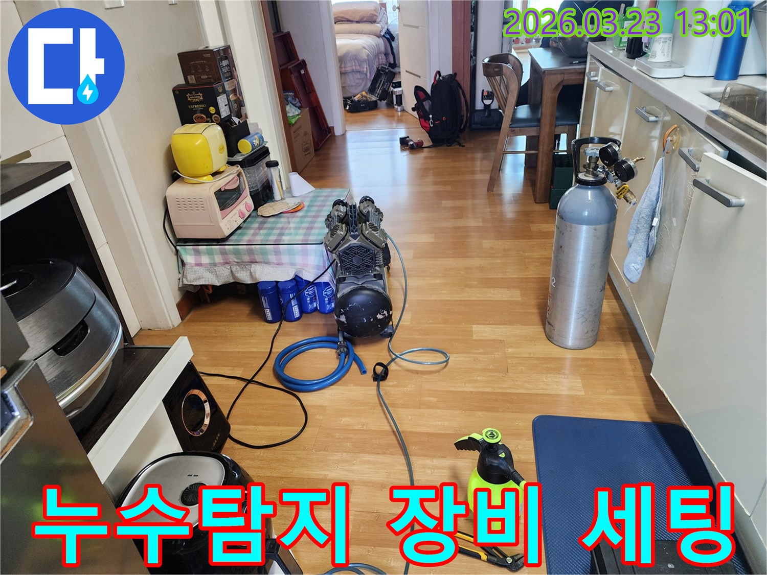 가정집 거실에서 누수 탐지를 위한 압력 테스트 장비와 공구가 놓여있는 장면